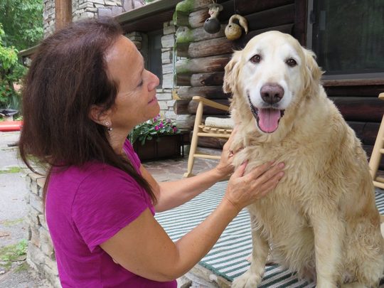 Donna Sue Rosenthal greeting a golden retriever